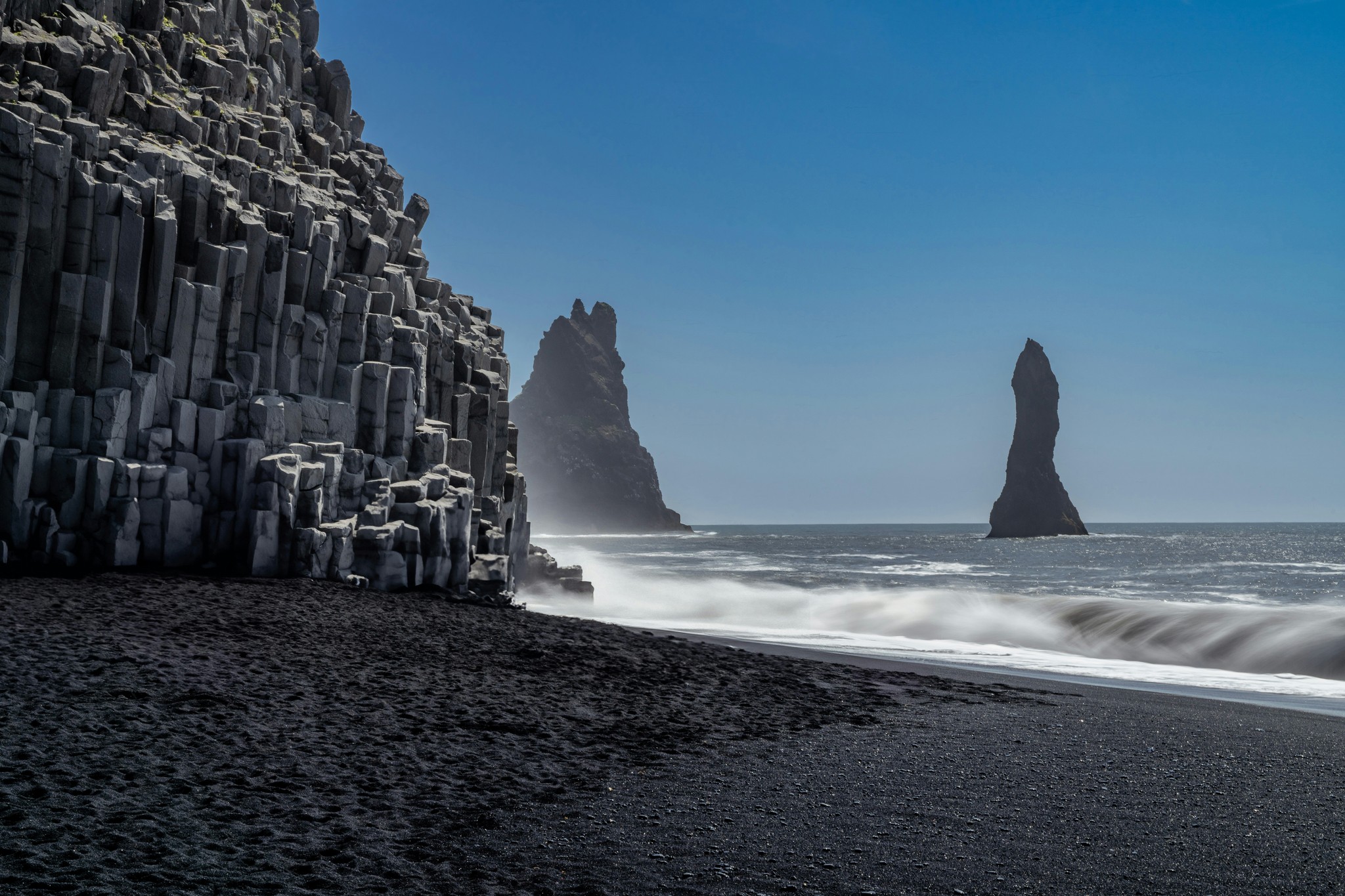 Reynisfjara Black Sand Beach with basalt columns and sea stacks in South Iceland.