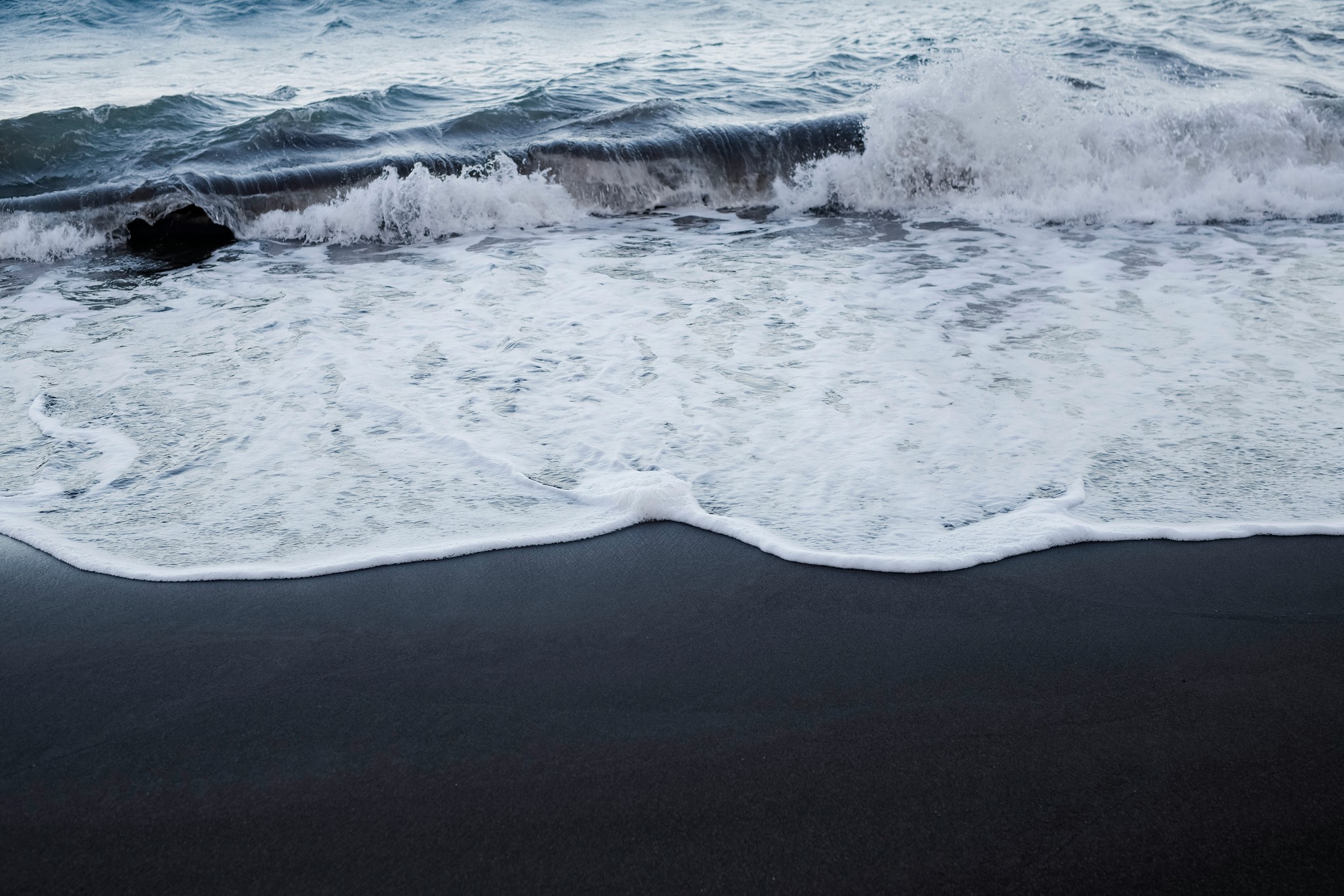 Waves crashing along a black sand beach on Iceland’s South Coast.