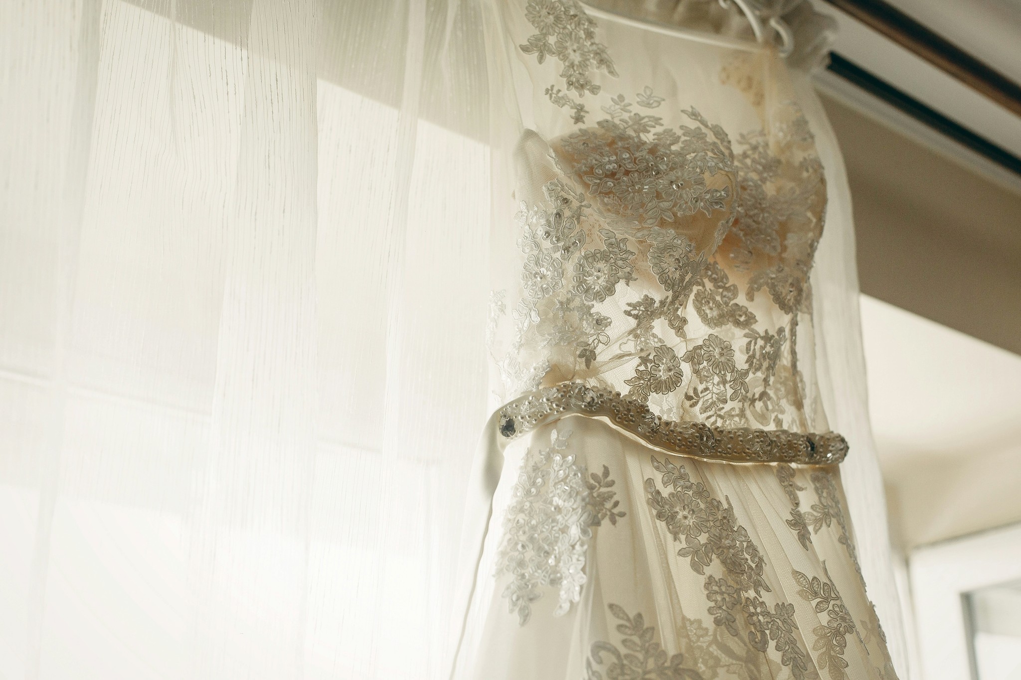 Elegant bridal gown hanging on a hanger before the ceremony.