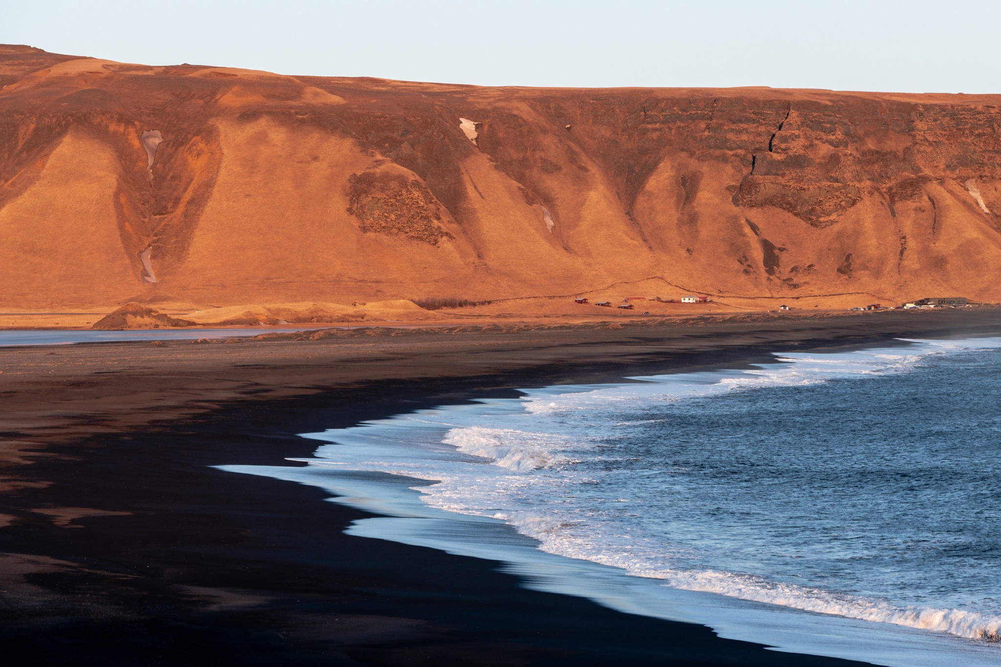 Black sand beach bathed in golden hour light in South Iceland.