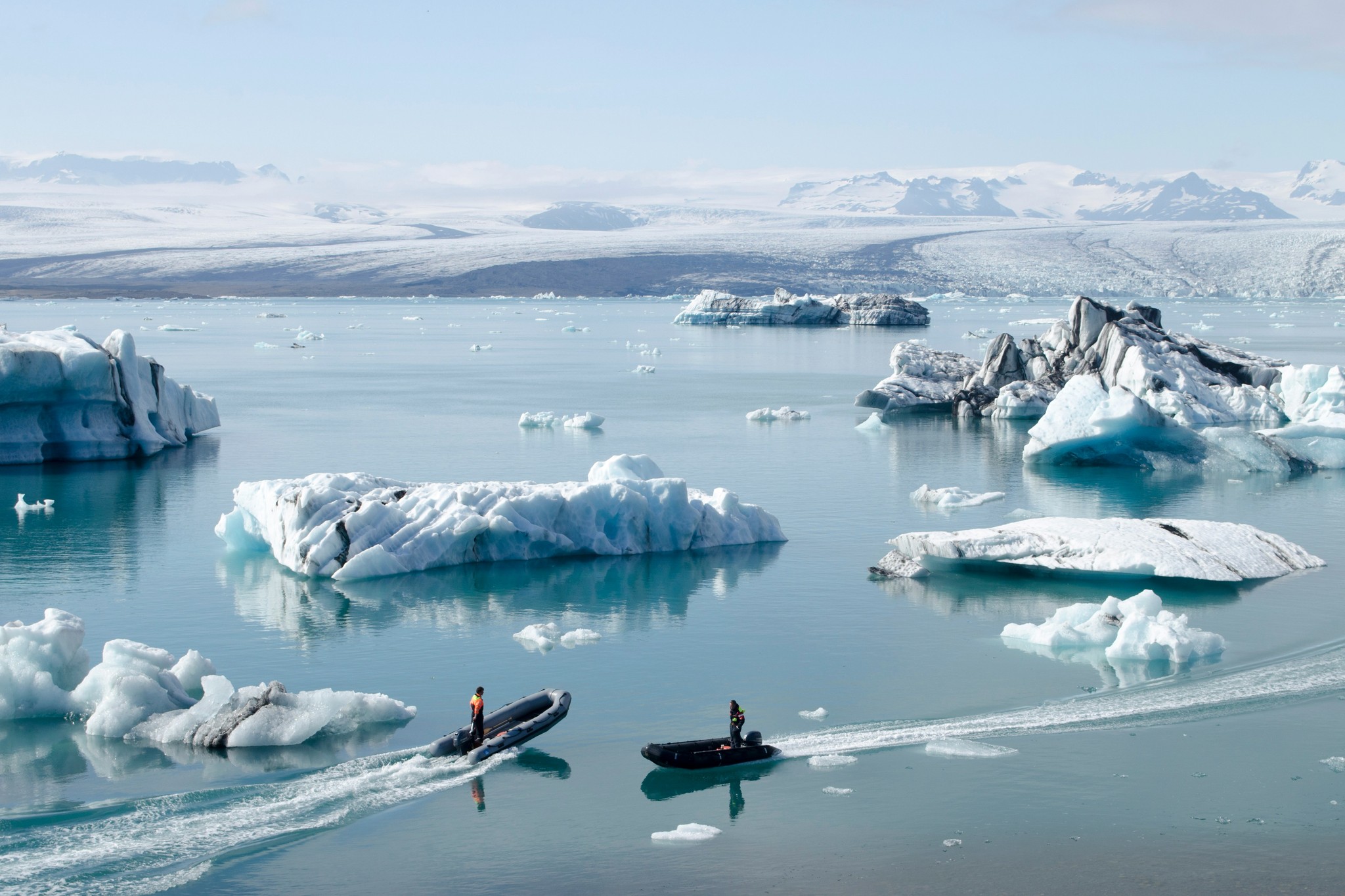 RIB boats navigating among icebergs at Jökulsárlón Glacier Lagoon in South Iceland.