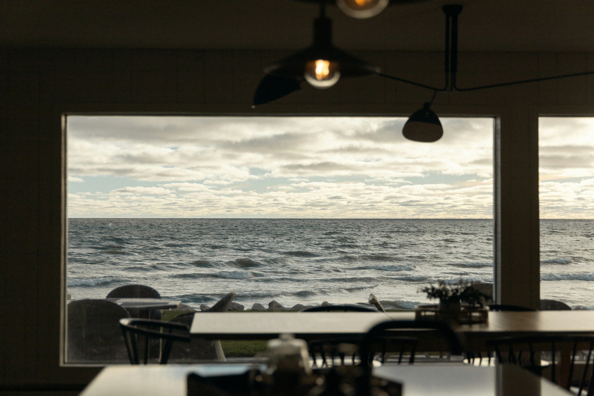 Restaurant with large windows overlooking the ocean.