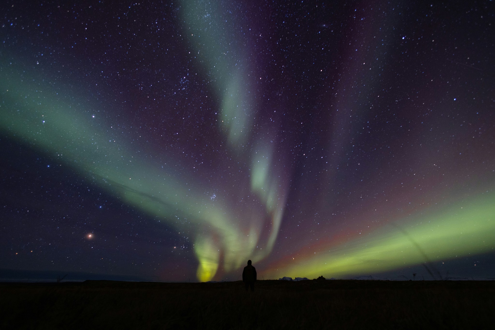 A person watching the northern lights in Iceland.