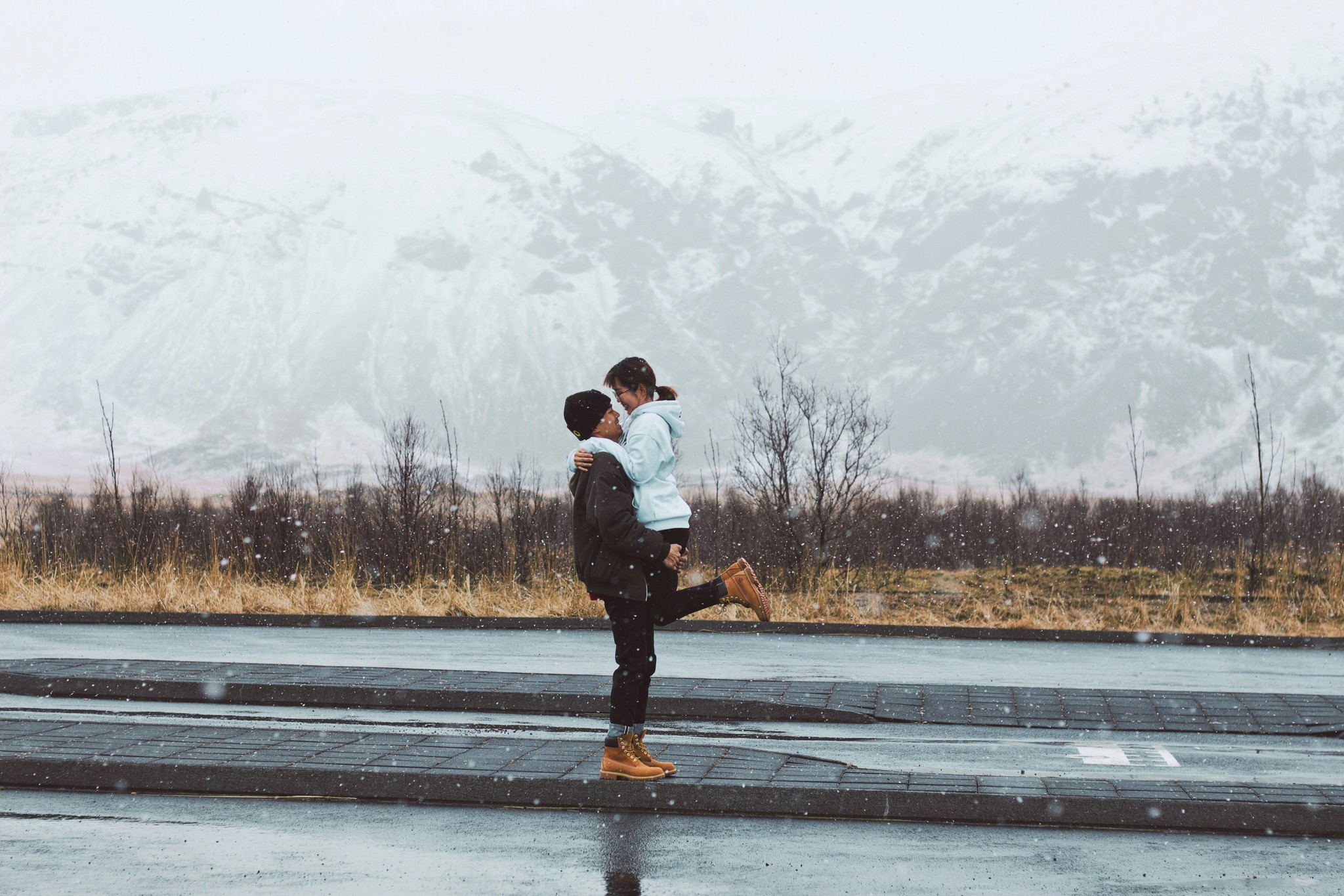 A couple posing by the road with Vatnajökull Glacier in the background.