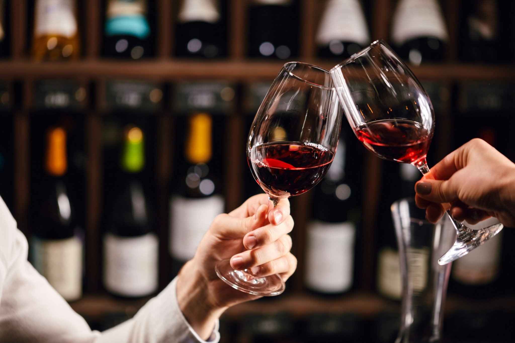 Two people clinking wine glasses at an upscale restaurant.